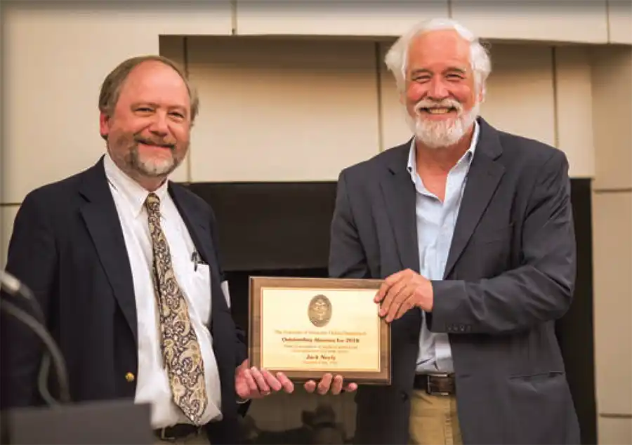 Neely accepts the Distinguished Alumnus award from Ernie Freenerg, professor and head of the Department of History