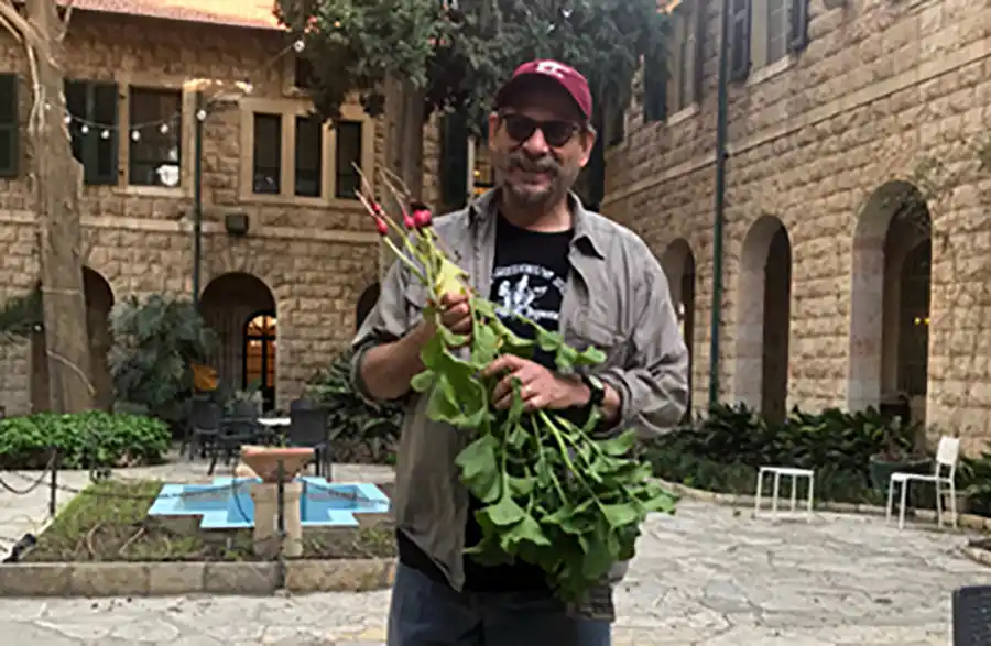 A picture of J.P. Dessel holding a bunch of radishes.